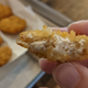 Hand holding bitten Impossible Chicken Nugget to display interior